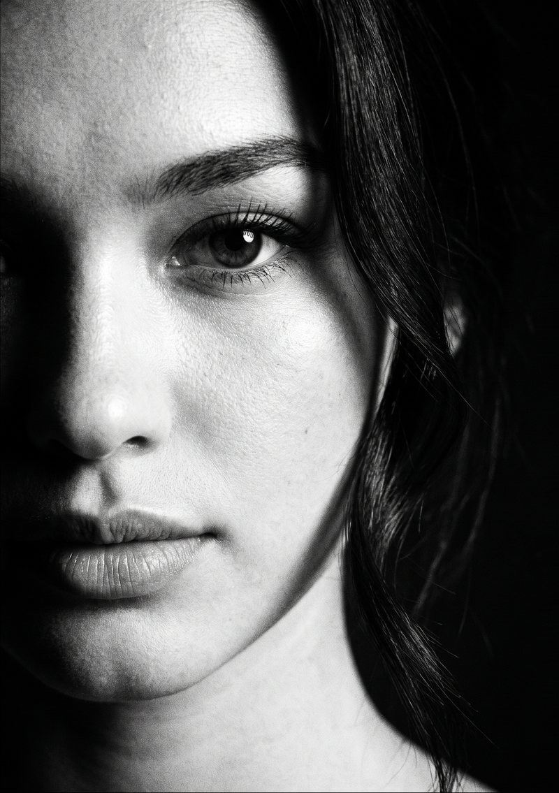 Nova Rai in a close portrait half in shadow, in black and white