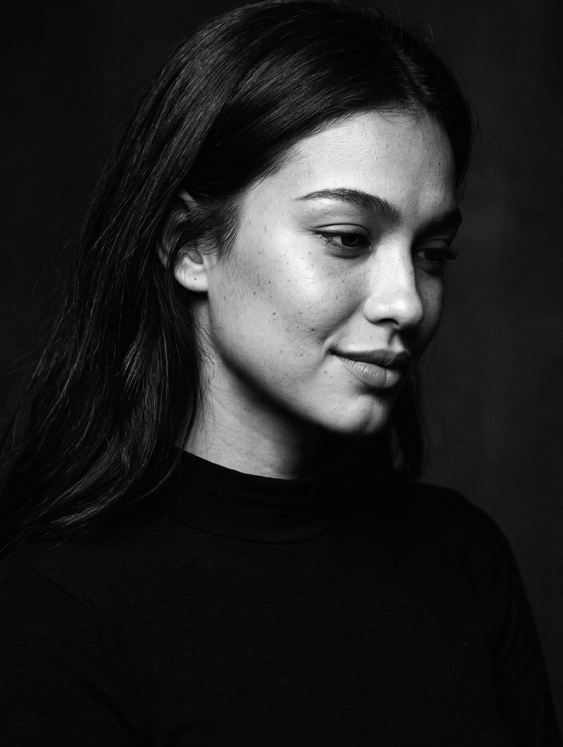 Nova Rai in a three-quarter portrait with a faint smile, in black and white