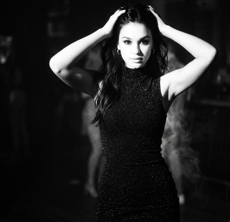 Nova Rai with her hands in her hair in the smoke, in black and white
